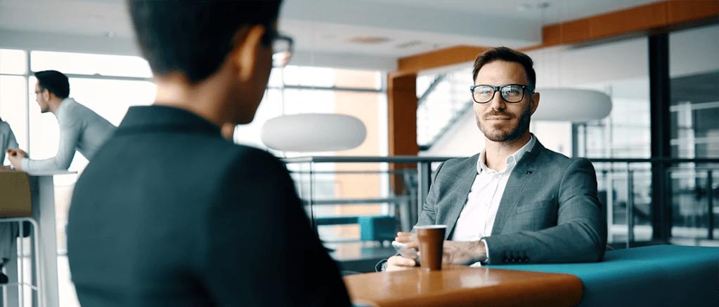 Dois homens de terno sentados em uma mesa