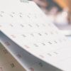 Close up white paper desk calendar with blurred bokeh background appointment and business meeting concept