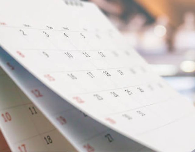 Close up white paper desk calendar with blurred bokeh background appointment and business meeting concept